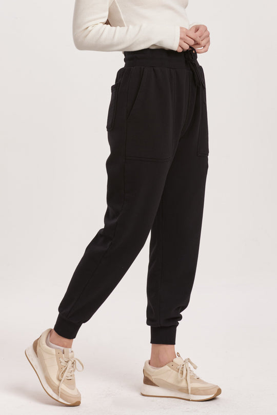 image of a female model wearing a DAHLIA HIGH RISE ANKLE JOGGER PANTS BLACK DEAR JOHN DENIM 