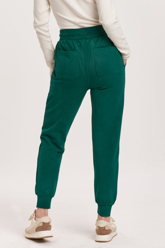 image of a female model wearing a DAHLIA HIGH RISE ANKLE JOGGER PANTS DEEP EMERALD DEAR JOHN DENIM 