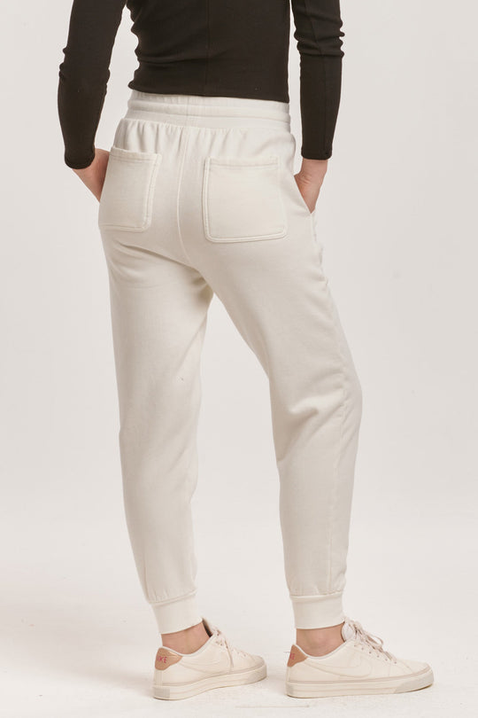 image of a female model wearing a DAHLIA HIGH RISE ANKLE JOGGER PANTS OFF WHITE DEAR JOHN DENIM 