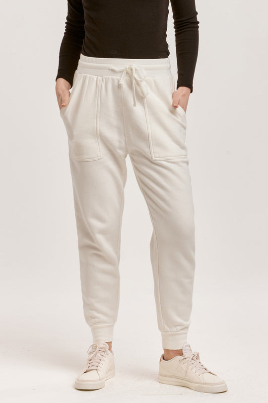 image of a female model wearing a DAHLIA HIGH RISE ANKLE JOGGER PANTS OFF WHITE DEAR JOHN DENIM 