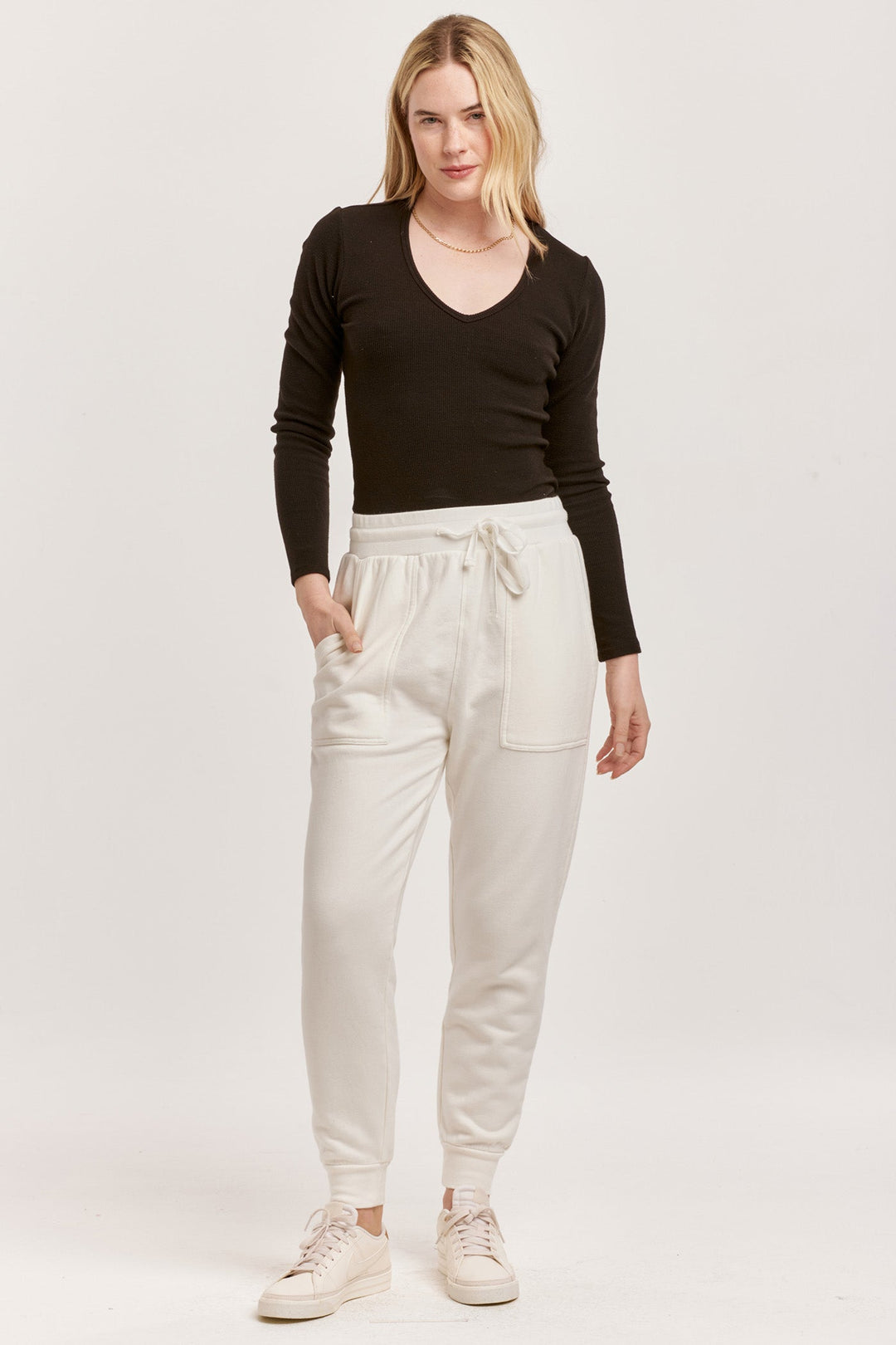 image of a female model wearing a DAHLIA HIGH RISE ANKLE JOGGER PANTS OFF WHITE DEAR JOHN DENIM 