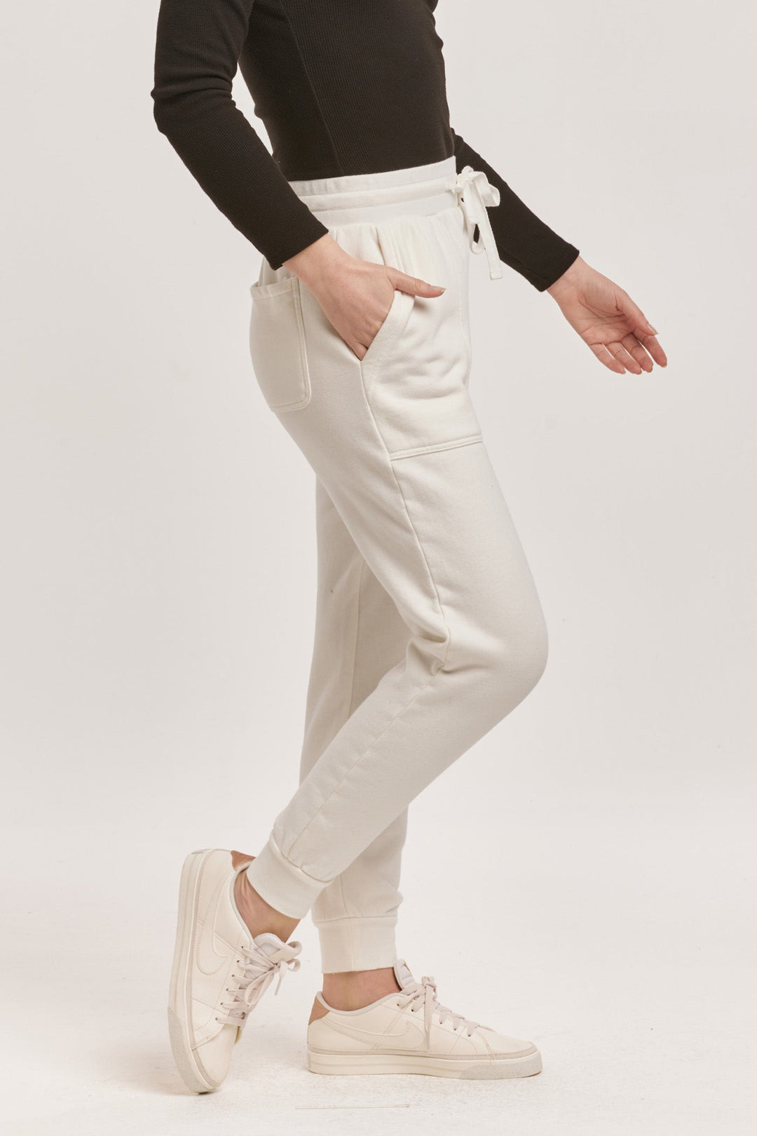 image of a female model wearing a DAHLIA HIGH RISE ANKLE JOGGER PANTS OFF WHITE DEAR JOHN DENIM 