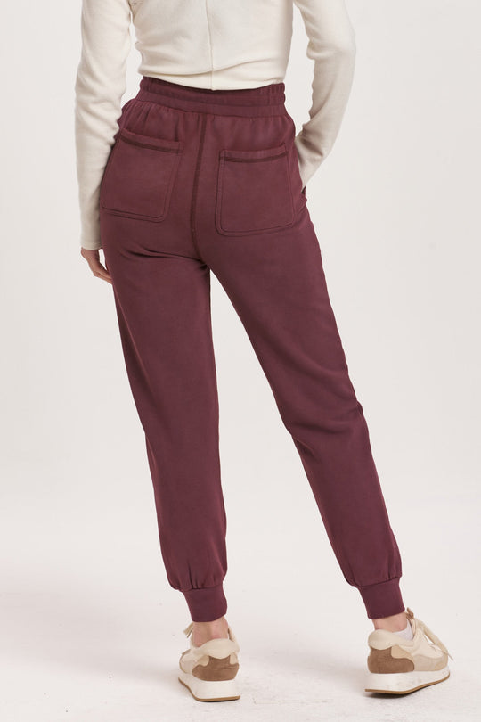 image of a female model wearing a DAHLIA HIGH RISE ANKLE JOGGER PANTS PLUM BERRY DEAR JOHN DENIM 