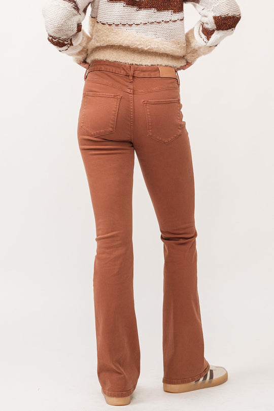 image of a female model wearing a JAXTYN MID RISE CLEAN HEM BOOTCUT JEANS BURNT SIENNA DEAR JOHN DENIM 