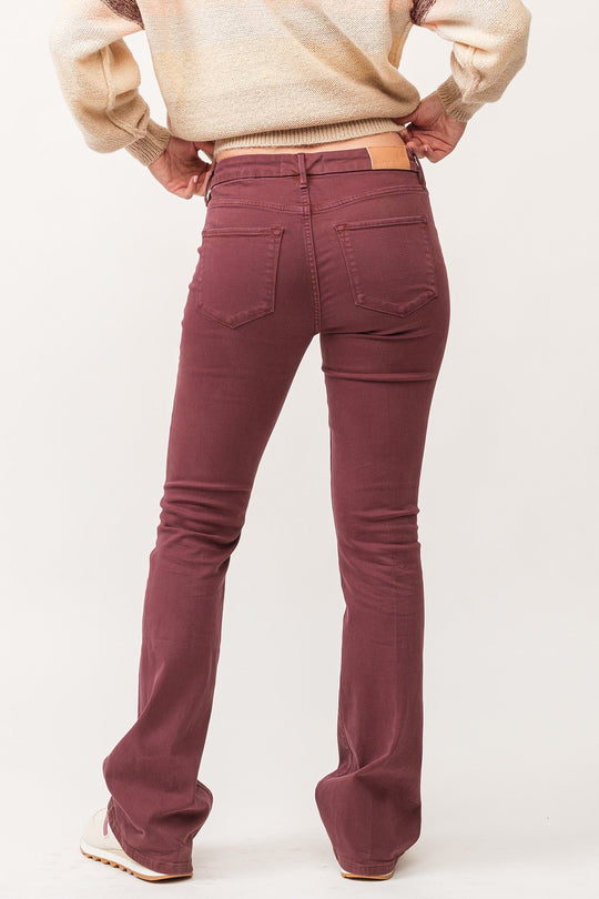 image of a female model wearing a JAXTYN MID RISE CLEAN HEM BOOTCUT JEANS MAROON DEAR JOHN DENIM 