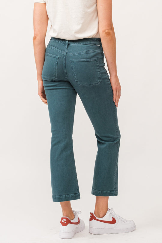 image of a female model wearing a JEANNE MID RISE CLEAN HEM FLARE JEANS DEEP TEAL DEAR JOHN DENIM 