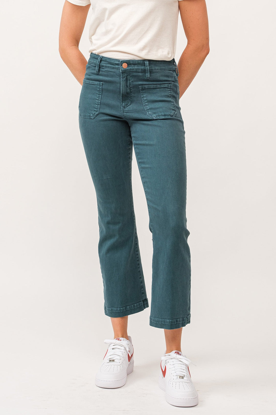 image of a female model wearing a JEANNE MID RISE CLEAN HEM FLARE JEANS DEEP TEAL DEAR JOHN DENIM 