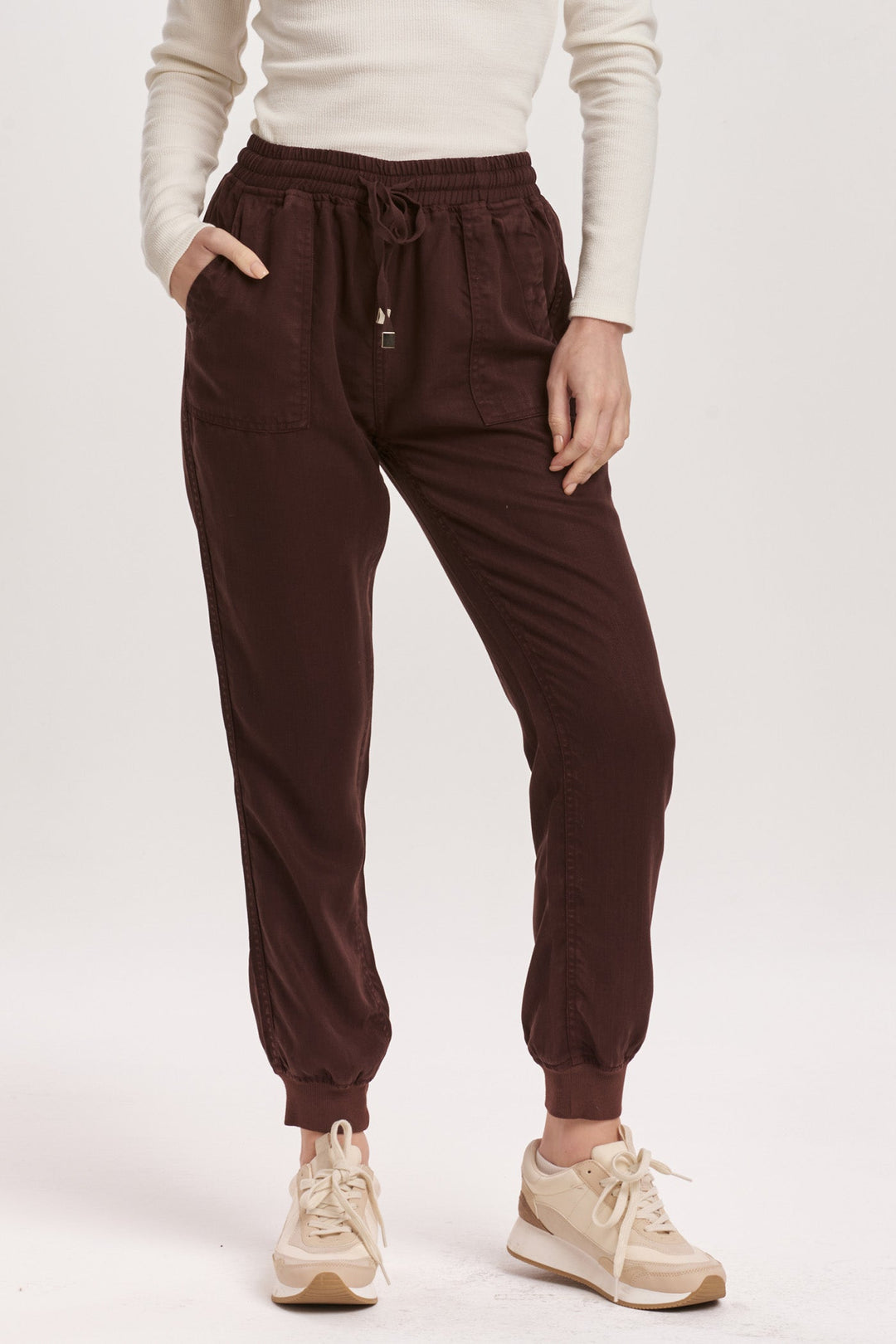 image of a female model wearing a JACEY SUPER HIGH RISE CROPPED JOGGER PANTS GROUND COFFEE DEAR JOHN DENIM 