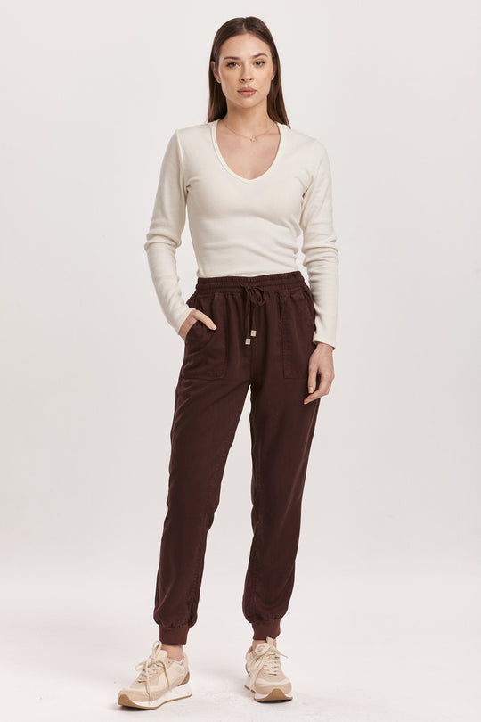 image of a female model wearing a JACEY SUPER HIGH RISE CROPPED JOGGER PANTS GROUND COFFEE DEAR JOHN DENIM 