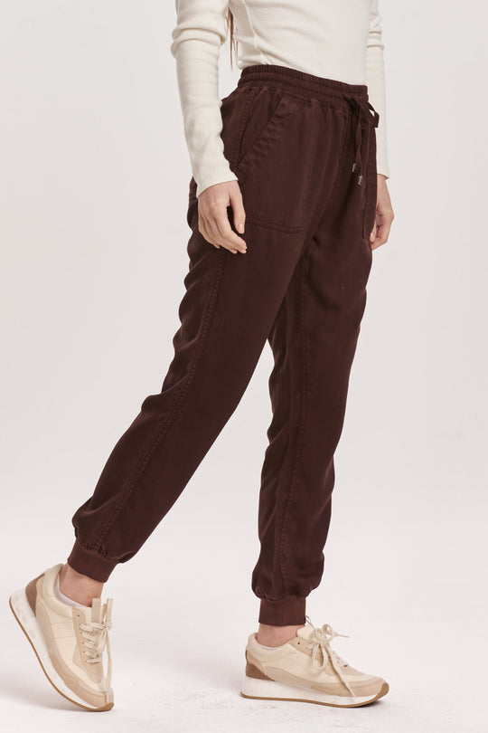 image of a female model wearing a JACEY SUPER HIGH RISE CROPPED JOGGER PANTS GROUND COFFEE DEAR JOHN DENIM 