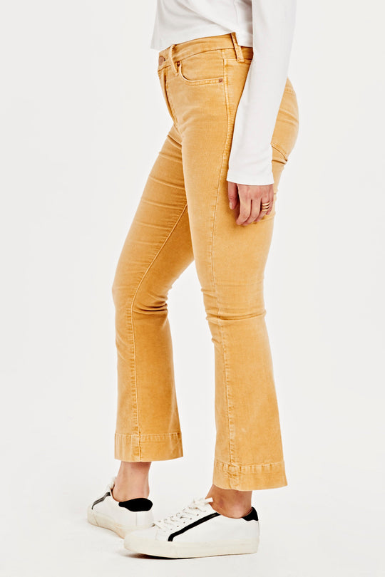image of a female model wearing a JEANNE SUPER HIGH RISE CROPPED FLARE CORDUROY PANTS SUNSET GOLD DEAR JOHN DENIM 