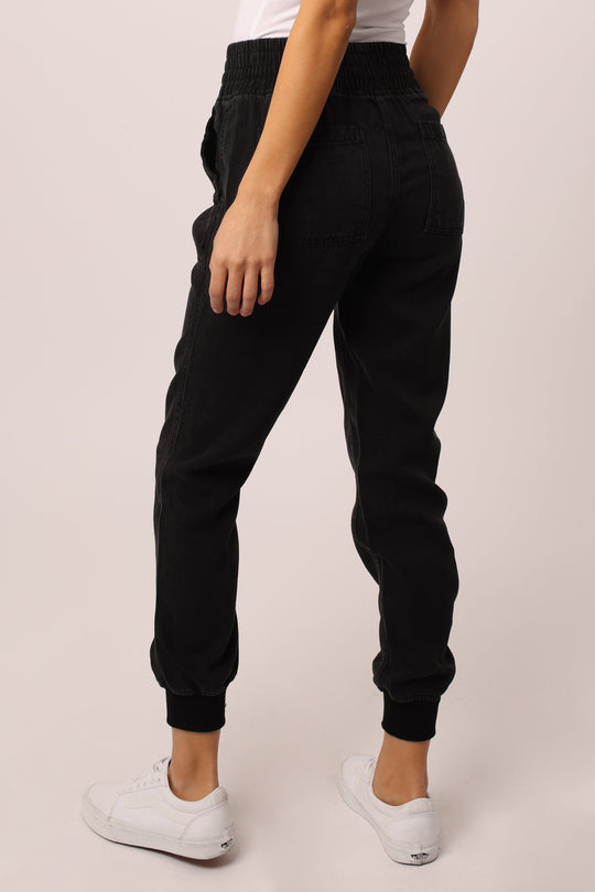 image of a female model wearing a JACEY SUPER HIGH RISE CROPPED JOGGER PANTS BLACK DEAR JOHN DENIM 