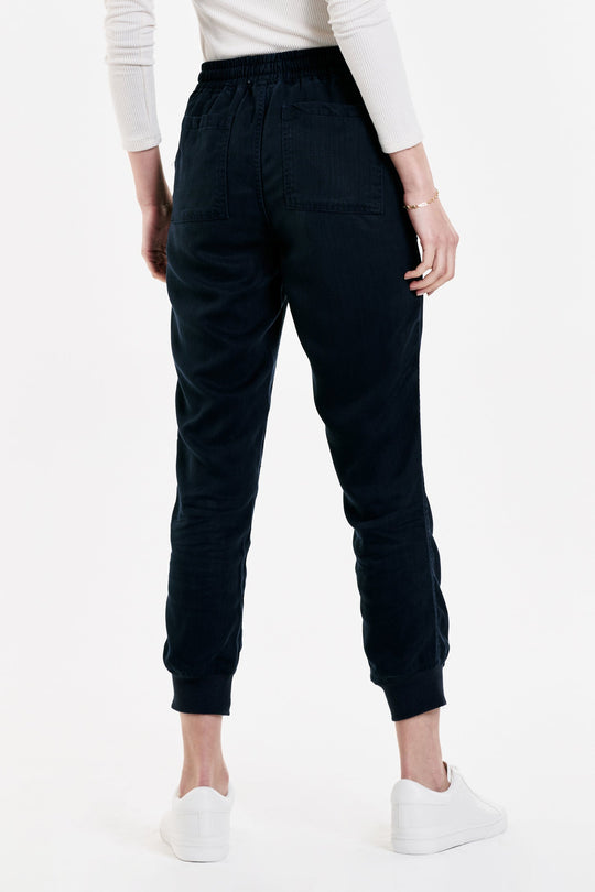 image of a female model wearing a JACEY SUPER HIGH RISE CROPPED JOGGER PANTS NAVY DEAR JOHN DENIM 