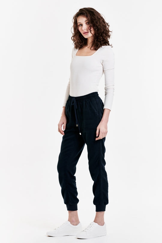 image of a female model wearing a JACEY SUPER HIGH RISE CROPPED JOGGER PANTS NAVY DEAR JOHN DENIM 