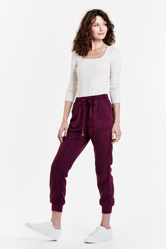 image of a female model wearing a JACEY SUPER HIGH RISE CROPPED JOGGER PANTS PURPLE POTION PANTS